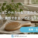 窓辺の木のテーブルに置かれたリネンのクロスと木製のヘアブラシ、ガラスの水差し、朝の光が差し込む静かな室内の静物イメージ