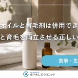 洗面台に並んだ無地のスプレーボトルとオイルの小瓶、たたんだタオル、木のコームが朝の光に照らされている静物イメージ