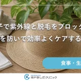木のテーブルに広いつばの帽子と麦わら帽子、通気性のよい生地が並ぶ明るい静物イメージ