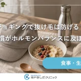 朝の木のテーブルに置かれたランニング用のキャップとたたんだタオル、水のボトル、果物を添えたオートミールの器が並ぶ静物イメージ