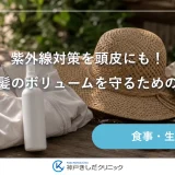 玄関の棚に置かれた日傘と帽子、頭皮用のUVスプレーと鍵が並ぶ明るい静物イメージ