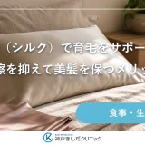 朝の寝室のベッドに置かれた光沢のあるシルクの枕カバーとたたんだリネン、やわらかな光が差し込む静物イメージ