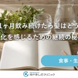 木のテーブルに文字のない無地のノートと万年筆、ガラスの水差し、たたんだ麻のクロス、小さな観葉植物が並ぶ静物イメージ