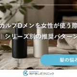 明るい室内の木のテーブルに麻のクロスを敷き、ラベルのない黒いボトルと乳白色のボトルを並べ、白い陶器の小皿とリネンのタオルを添えた静物イメージ