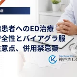 診察室の机の上に置かれたお薬手帳と血圧計を、医師と中年男性が一緒にのぞき込んでいる場面のイメージ